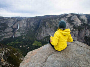 Water bottle in hand, a person enjoying the view on a hiking tour.